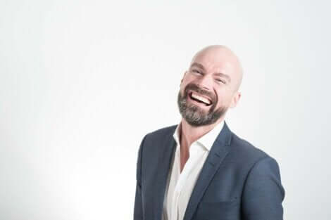 En man i kostym ler stort