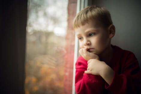 En liten pojke som ser ut genom fönstret