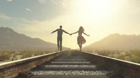 Ett lyckligt par som går längst ett tågspår