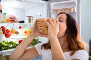 En kvinna poserar med en enorm smörgås