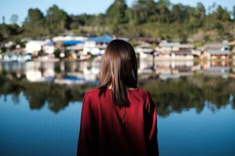 En kvinna som ser över en sjö mot en liten by