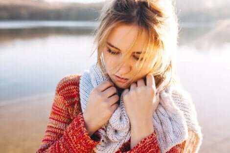 En sorgsen kvinna framför en insjö