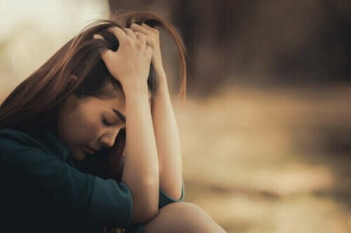 En ledsen kvinna tänker på sörjandets fyra uppgifter