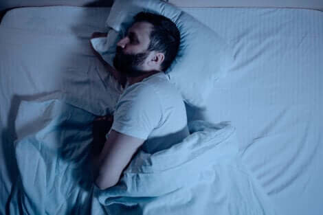 En man sover på sidan i sin säng