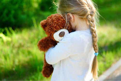 En flicka som kramar sin nallebjörn