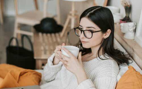 En kvinna som bär glasögon som dricker kaffe