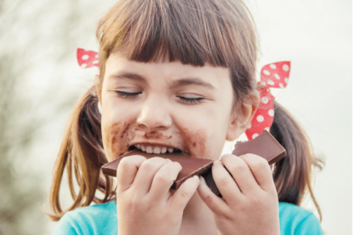 Flicka som äter choklad